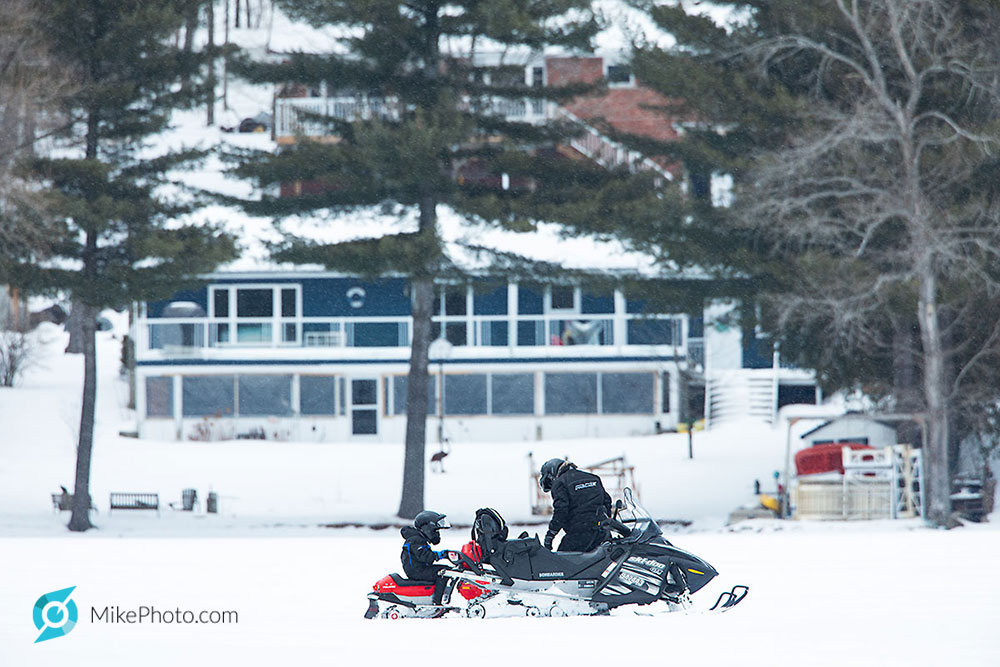 Father and child on snowmobiles