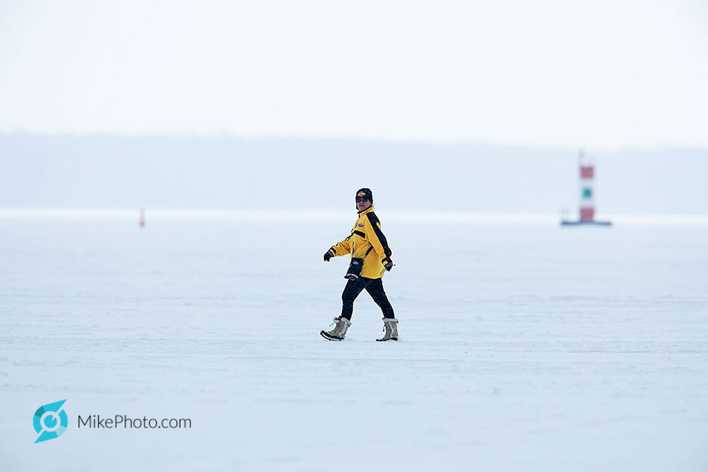 Woman walking on frozen bay with the Penetang Harbour daymark in the background